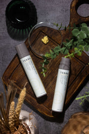 Terra serum flat lay with kokum butter and cedar, Ayurvedic barrier-care ritual showcasing the creamy texture