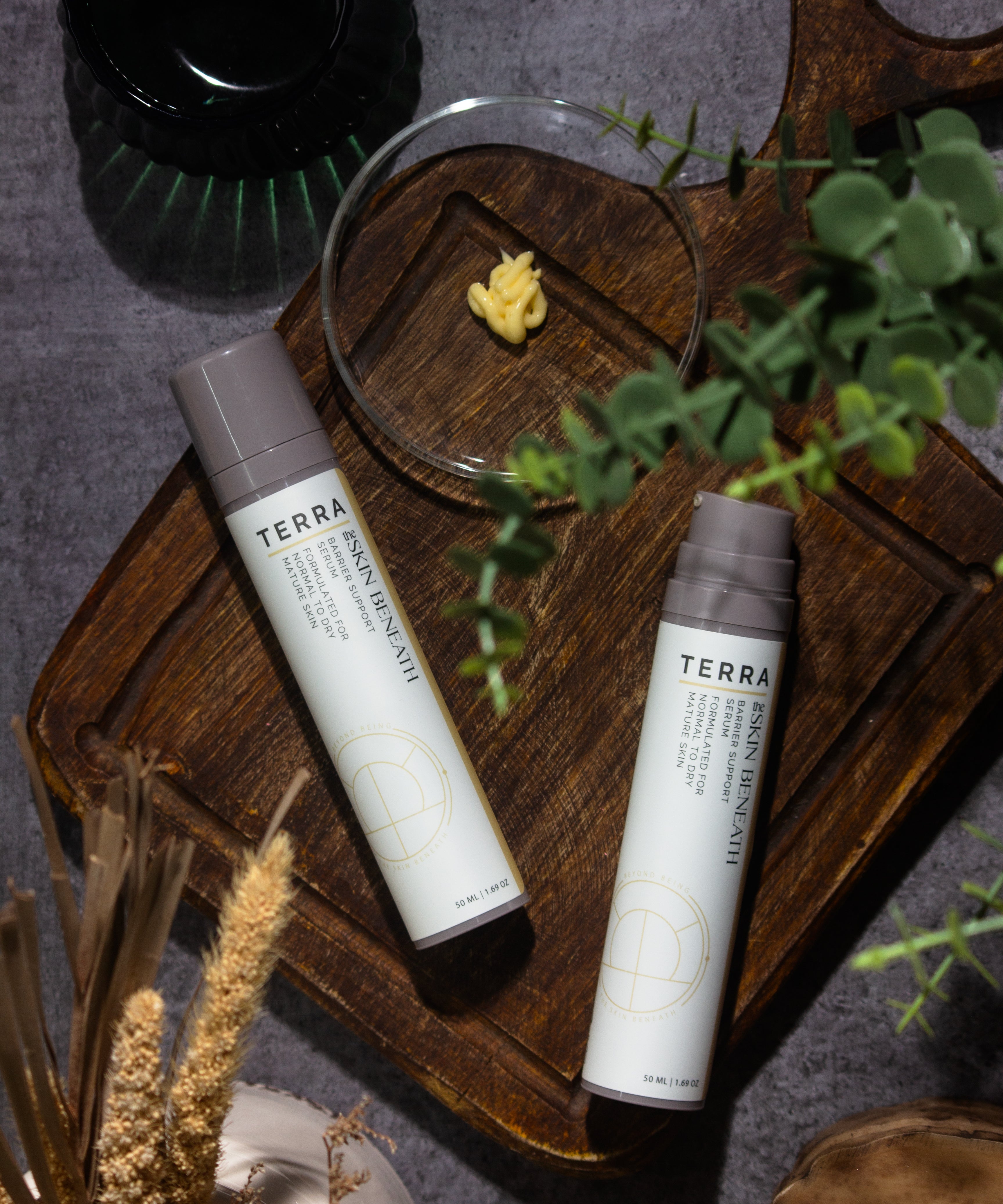 Terra serum flat lay with kokum butter and cedar, Ayurvedic barrier-care ritual showcasing the creamy texture