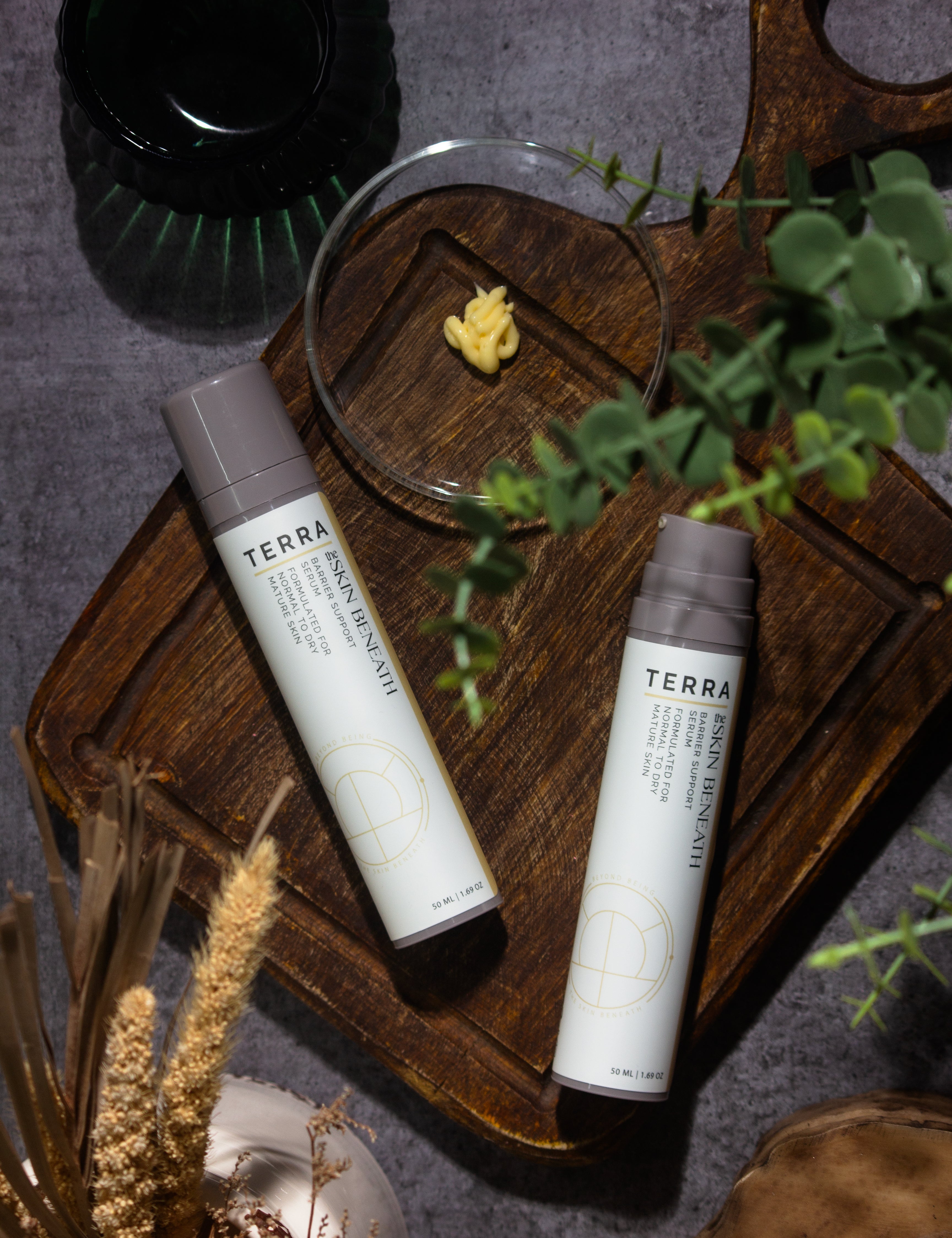 Terra serum flat lay with kokum butter and cedar, Ayurvedic barrier-care ritual showcasing the creamy texture