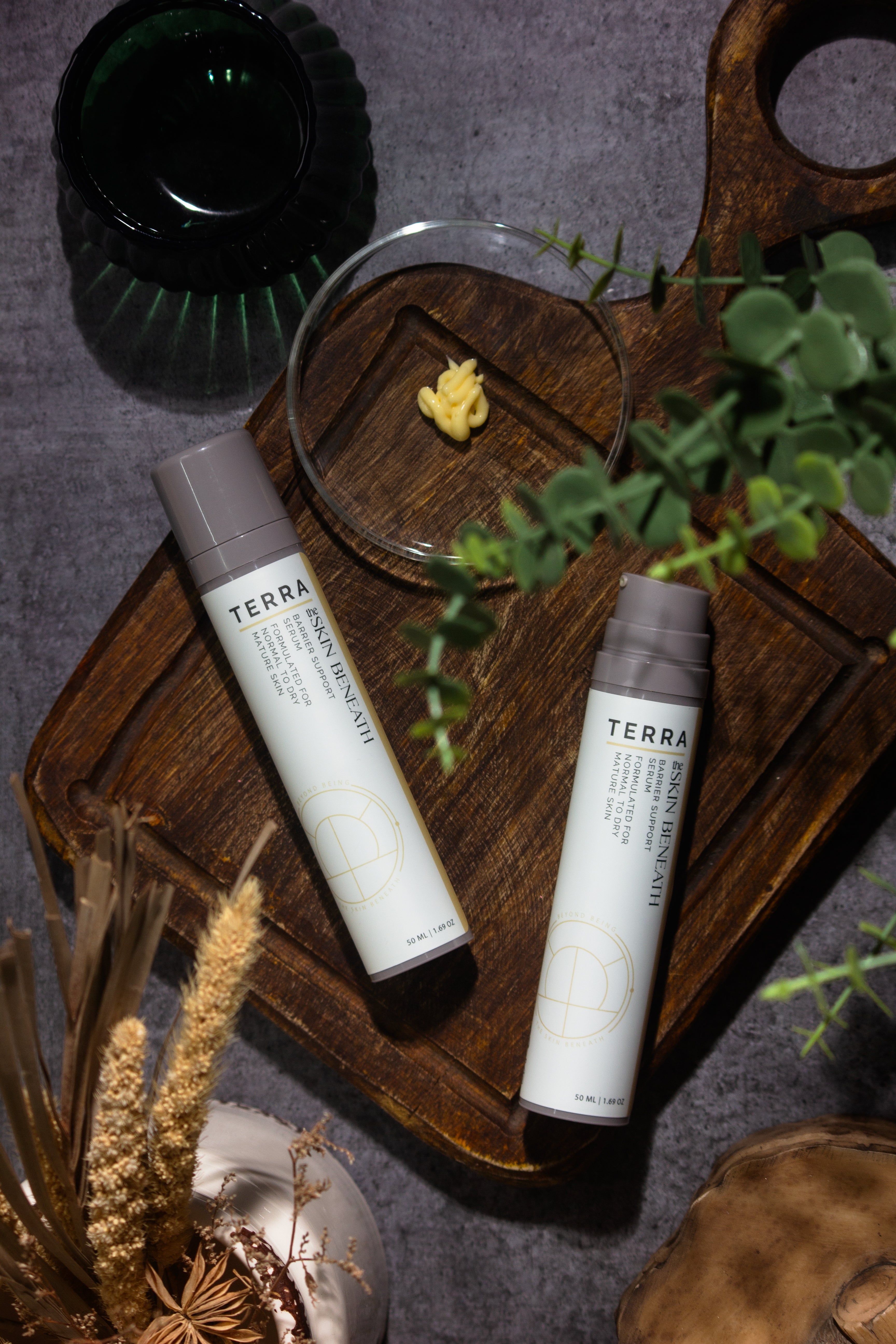 Terra serum flat lay with kokum butter and cedar, Ayurvedic barrier-care ritual showcasing the creamy texture