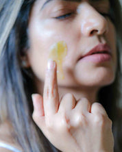 Woman applying Cedar of the Forest cleansing balm during evening skincare routine