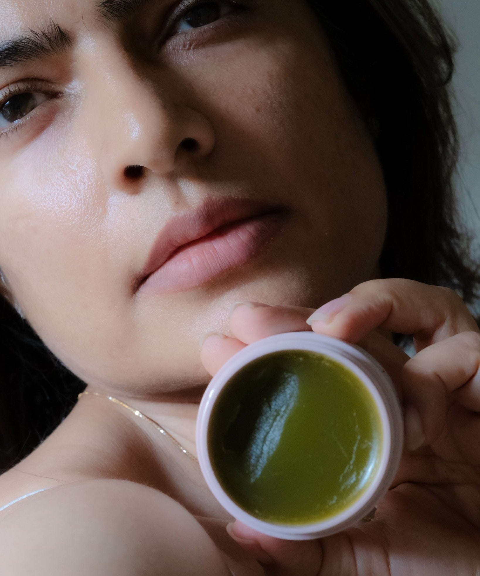 Woman holding Cedar of the Forest cleansing balm during skincare routine