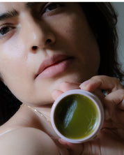 Woman holding Cedar of the Forest cleansing balm during skincare routine