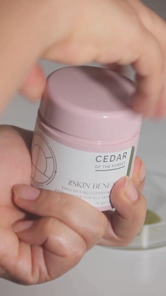 Cedar of the Forest cleansing balm with rich, buttery texture scooped by finger — shows balm-to-oil transformation on contact